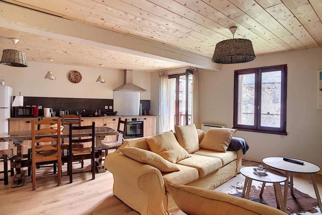 a living room with a couch and a table at Maison de village spacieuse au calme in Matemale