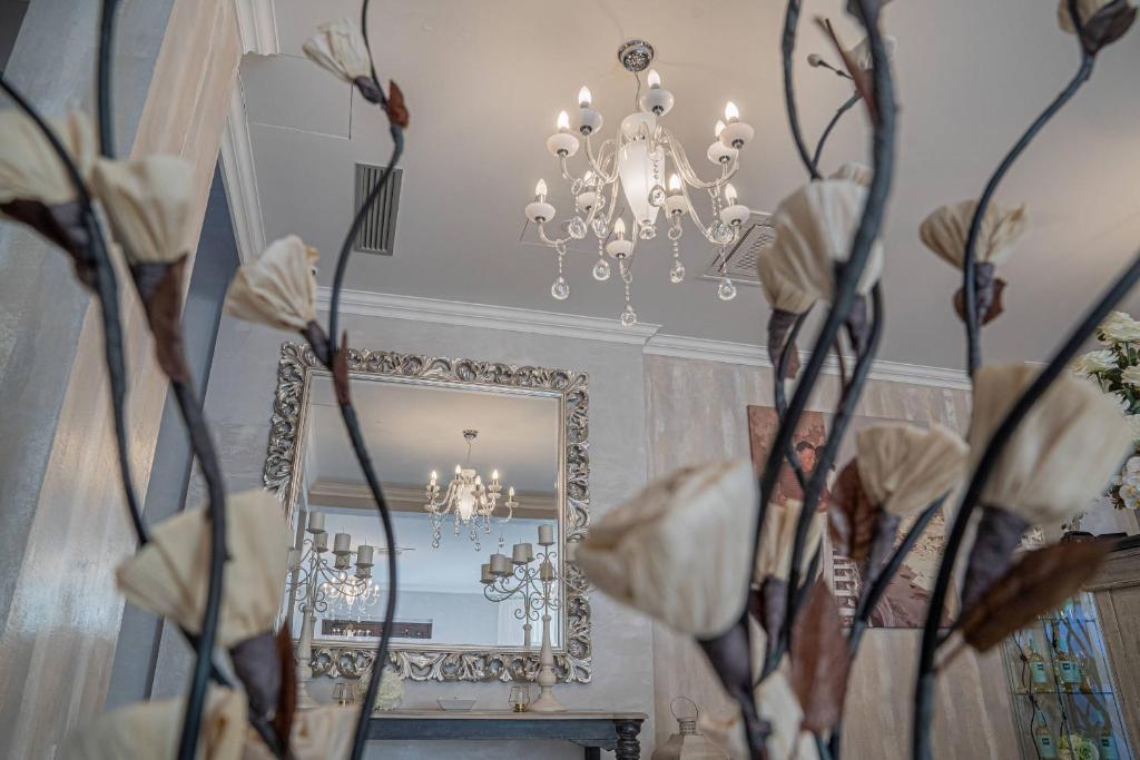 a room with a mirror and a chandelier and flowers at Hotel Colomba D'Oro in Tropea