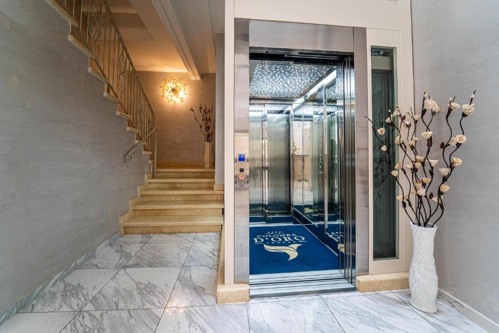 a hallway with a door with a vase and stairs at Hotel Colomba D'Oro in Tropea