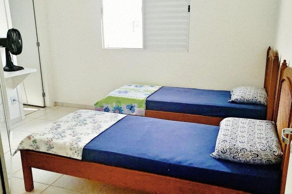 two twin beds in a room with a window at SHANTI-APTO INCRÍVEL INTEIRO, 1SUÍTE & WIFI, 1 DORM máx 4 pessoas in São Carlos