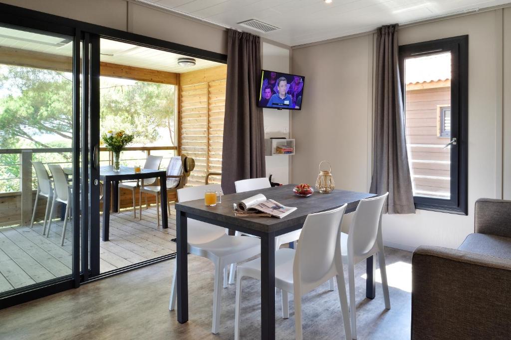 a dining room and living room with a table and chairs at Résidence & Hotel U Livanti ECOLABEL in Propriano