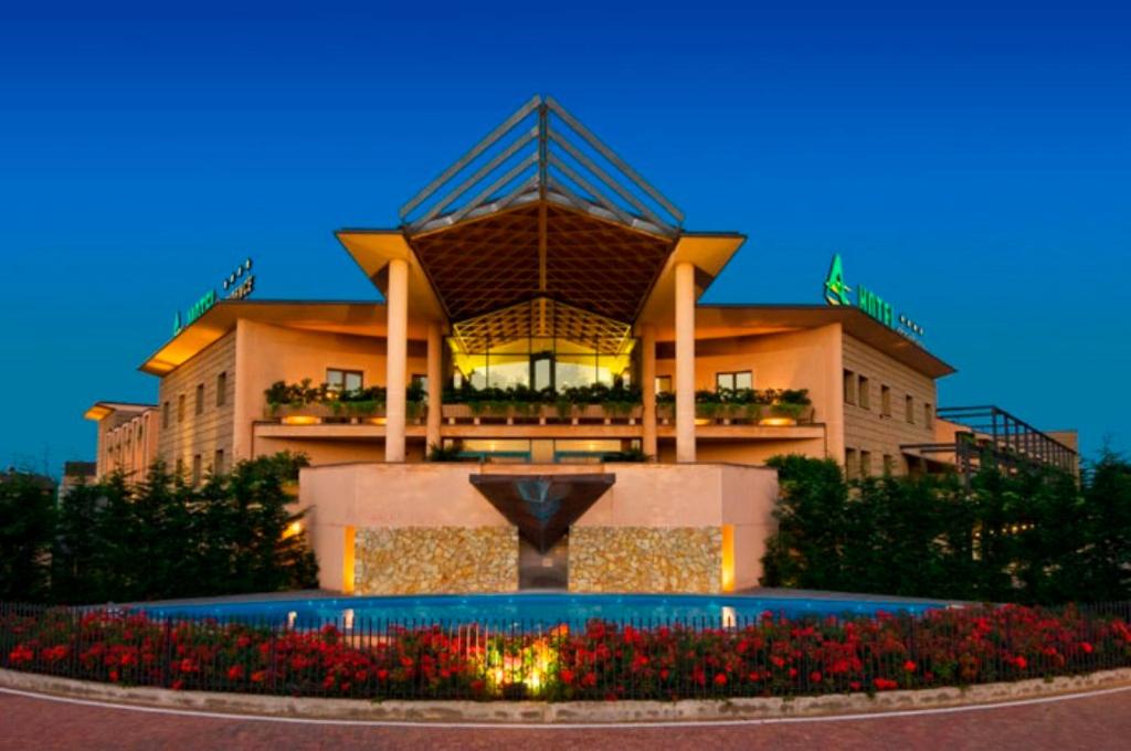 a building with a fountain in front of it at As Hotel Cambiago in Cambiago