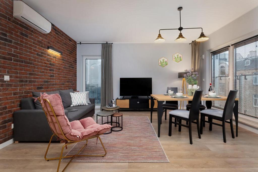 - un salon avec un canapé et une table dans l'établissement Exclusive Apartments Mostowa by Renters Prestige, à Poznań