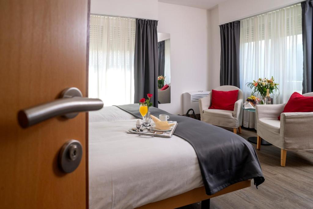 SementinaにあるHotel Ceredaのベッド1台、テーブル、椅子が備わるホテルルームです。