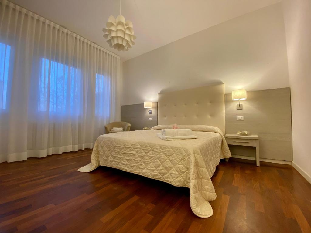 een slaapkamer met een bed en een groot raam bij Villa Alda Suites & Rooms in Cervia