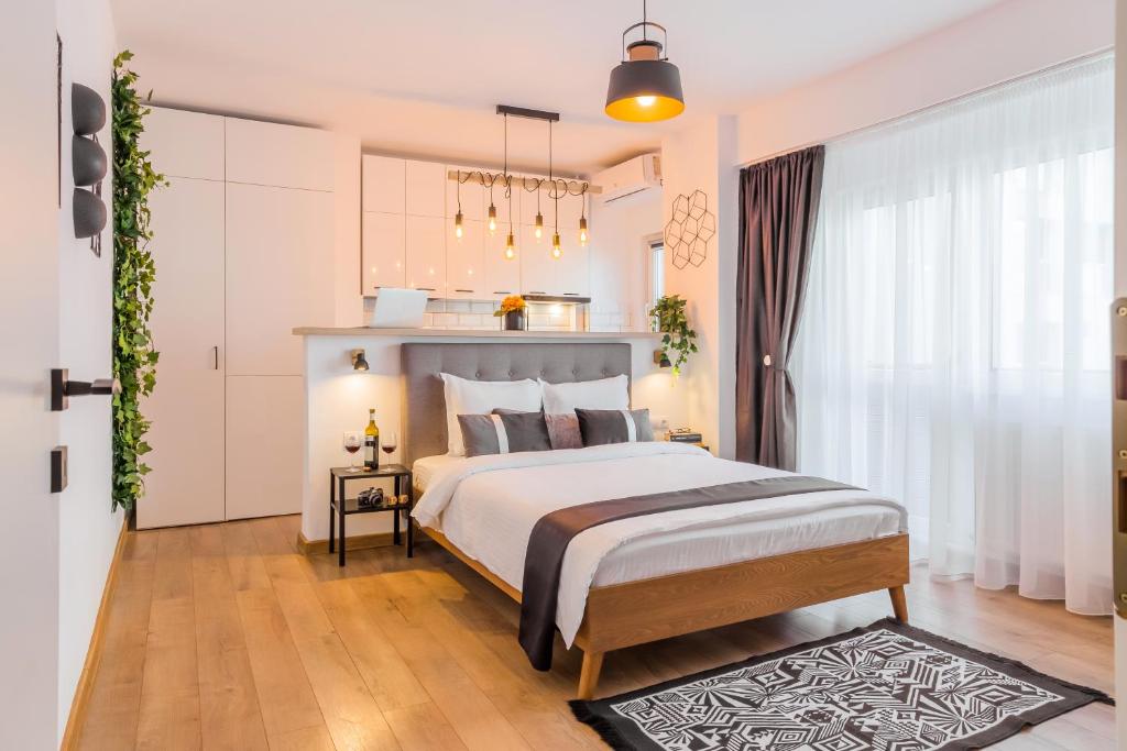 Un dormitorio con una cama y una ventana grande. en Timpuri Noi - Studio 54 by MRG Apartments, en Bucarest