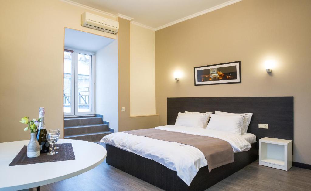 a bedroom with a bed and a table in it at Khreshchatyk Apart Hotel Passage in Kyiv