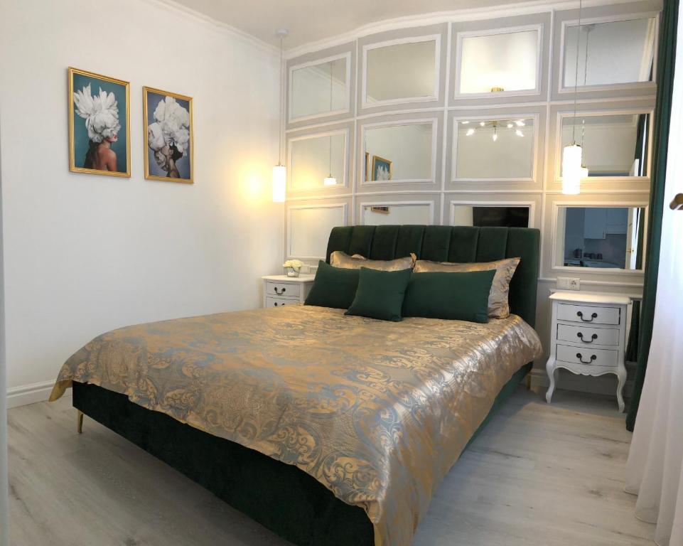 1 dormitorio con 1 cama grande y 2 mesitas de noche en Luxury Emerald Apartments, en Irpín