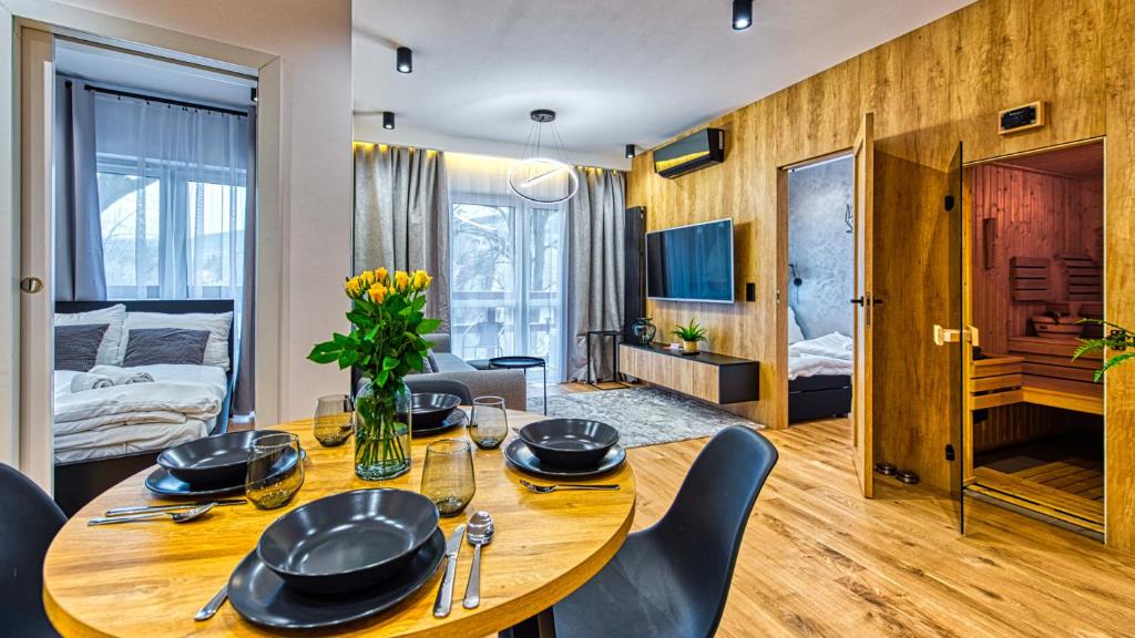 una sala da pranzo con tavolo e sedie e una camera da letto di Apartament Wood Lux - 5D Apartamenty a Świeradów-Zdrój