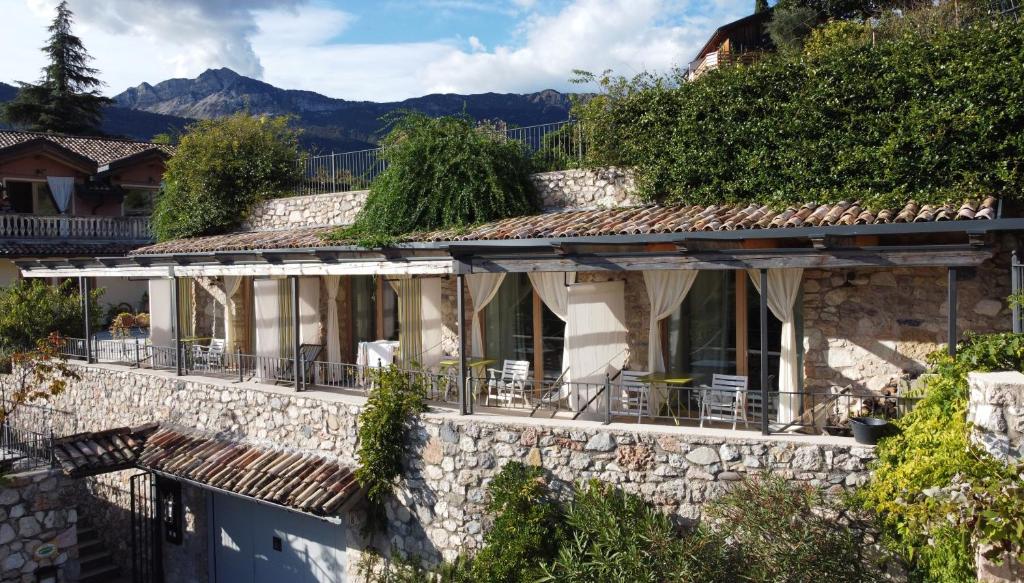 Casa del Pittore في روفيريتو: منزل حجري على طاولات وكراسي في الشرفة