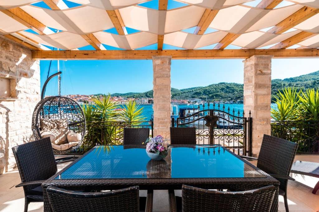 un patio con mesa y sillas y vistas al agua en Luxury Apartment Marina View No 1, en Vela Luka