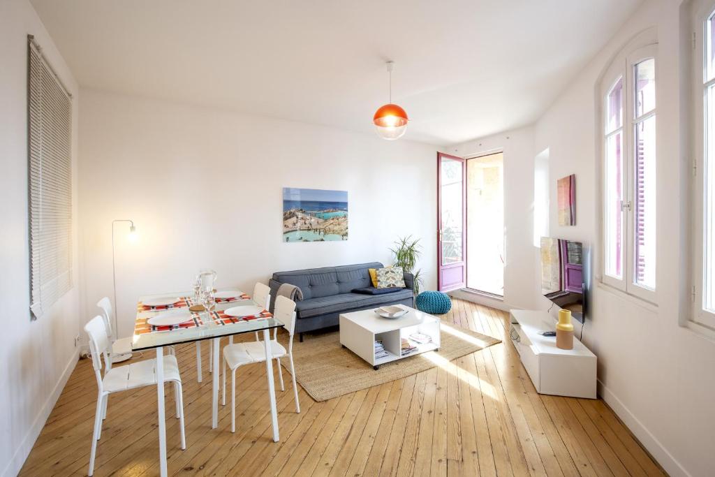 un salon avec un canapé bleu et une table dans l'établissement Place Saint Michel Apartment, à Bordeaux