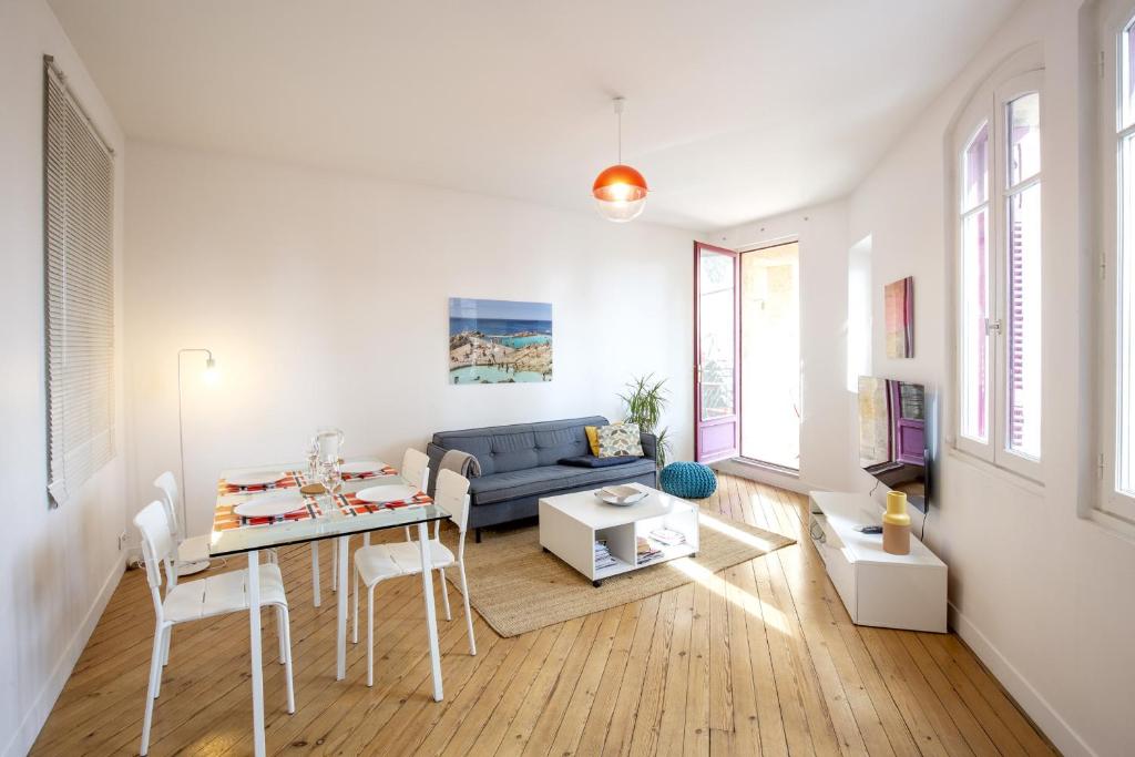 - un salon avec un canapé bleu et une table dans l'établissement Place Saint Michel Apartment, à Bordeaux