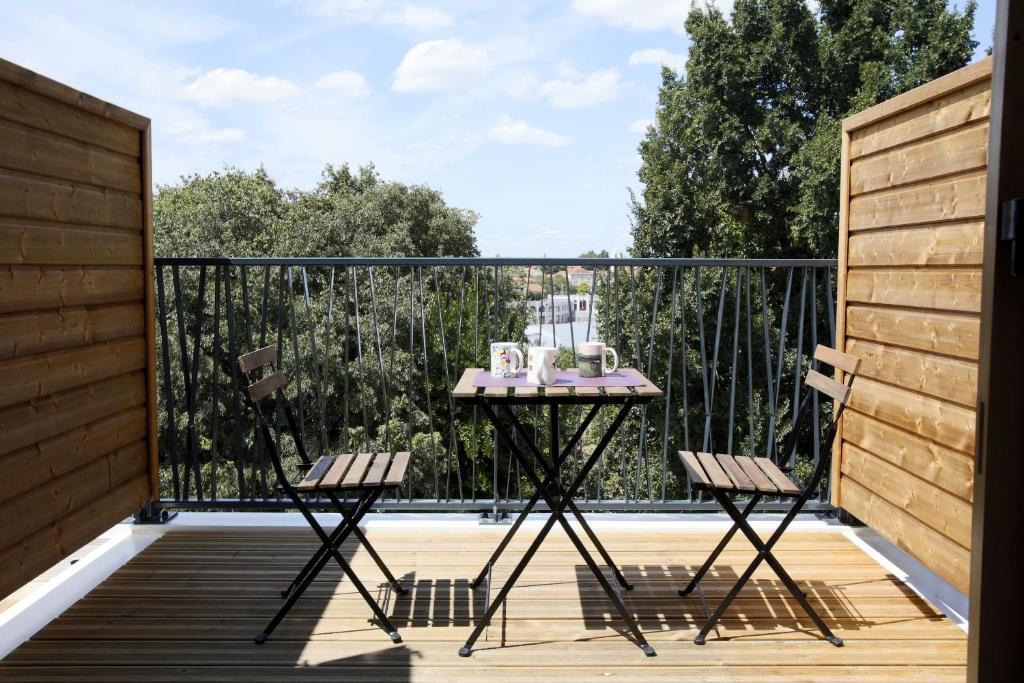 une table et deux chaises sur un balcon dans l'établissement Les Terrasses de Louise, à Bordeaux
