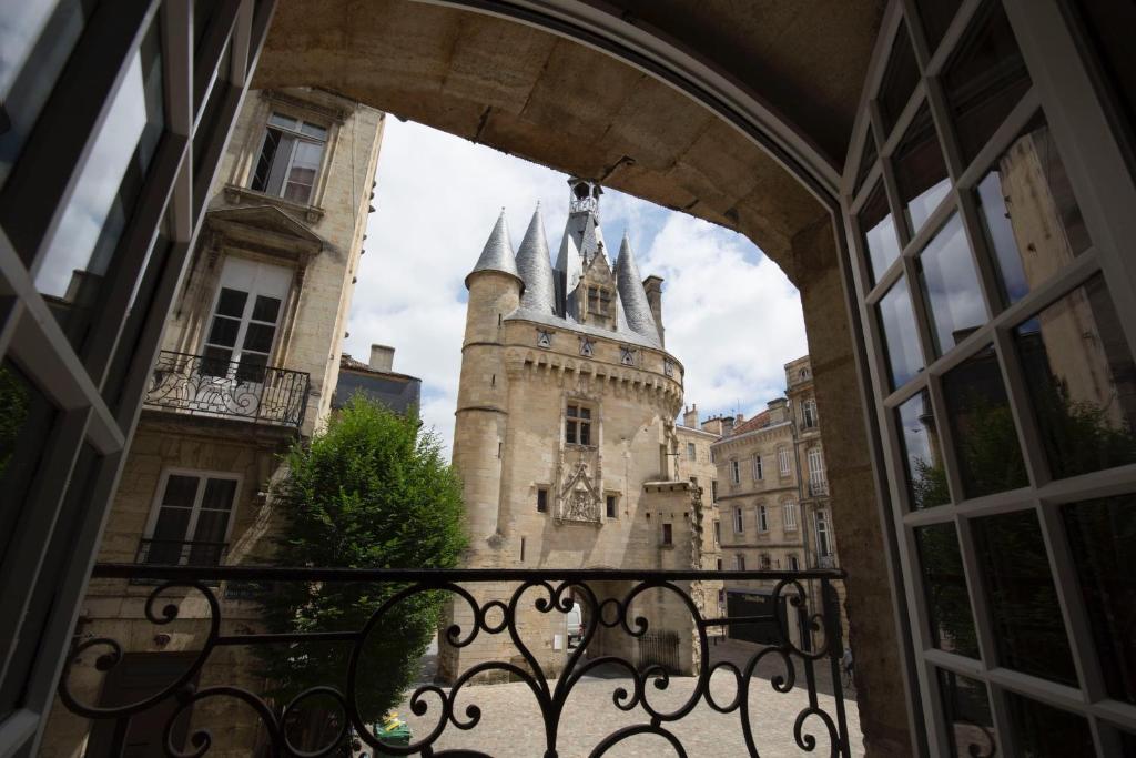 een boog met een kasteel op de achtergrond bij Place du Palais in Bordeaux