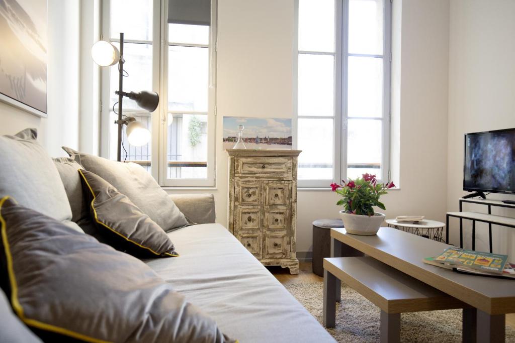 un salon avec un canapé et une table dans l'établissement Centre historique - Le Maubec, à Bordeaux