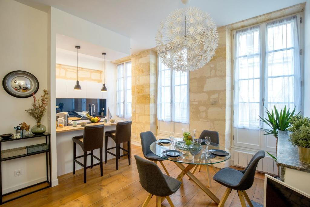 eine Küche und ein Wohnzimmer mit einem Tisch und Stühlen in der Unterkunft Appartement Luxe - La Devise in Bordeaux