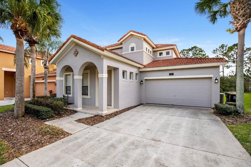 a house with a garage and palm trees at Gorgeous Davenport 5 Bed Villa with Pool Hot Tub in Davenport