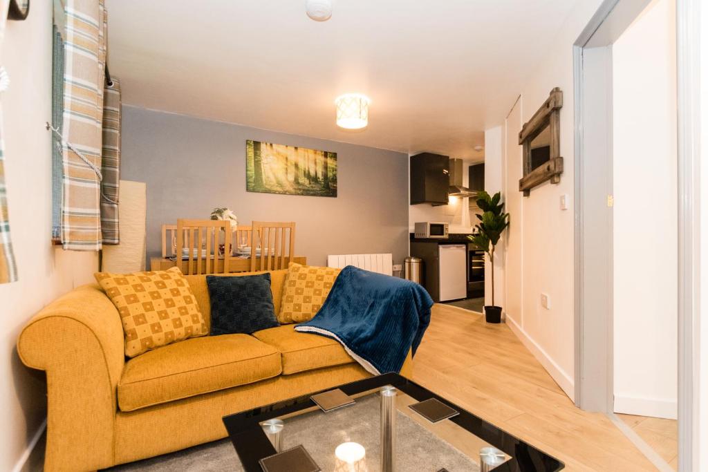 a living room with a yellow couch and a table at Newton Apartment nr Wigan Hospital in Wigan