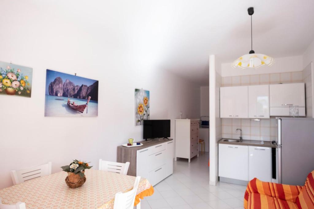 a kitchen and dining room with a table and a refrigerator at Appartamento Sole in San Vito lo Capo