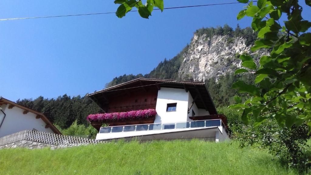 a building with flowers on the side of a hill at Ferienwohnung Zuppinger in Mayrhofen