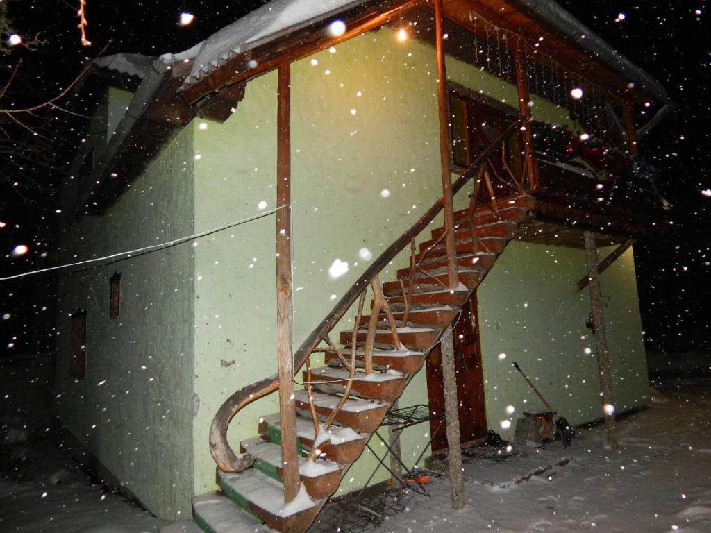 una escalera de madera en un edificio en la nieve en Відпочинок у Євгена та Оксани, en Yaremche