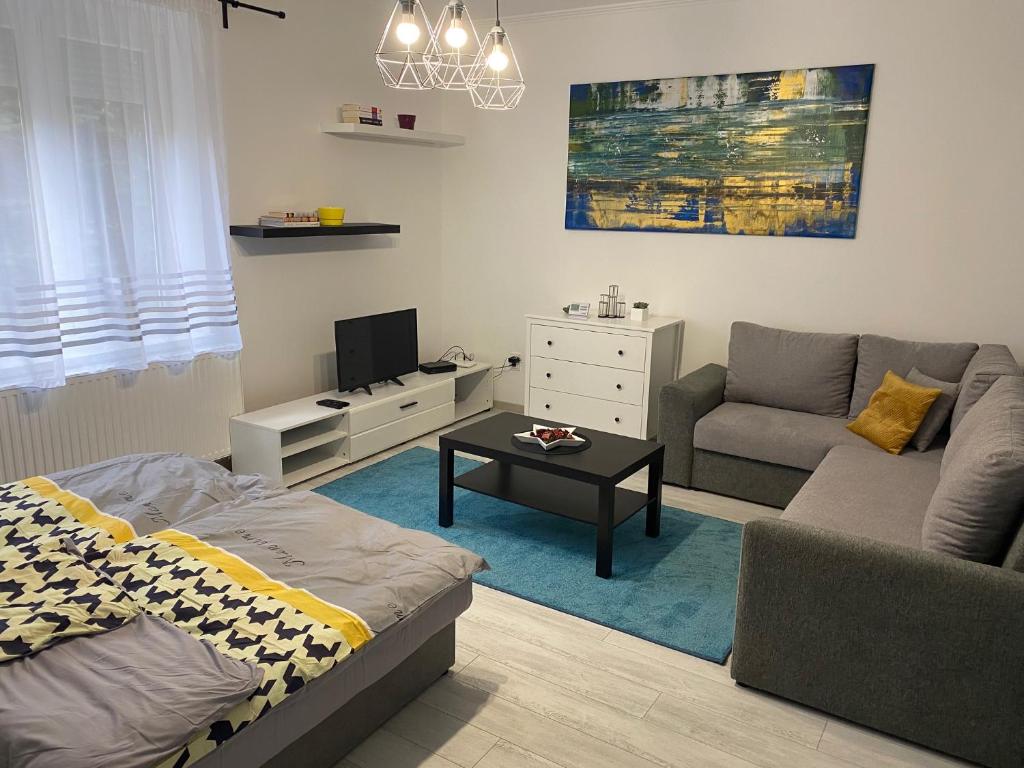 uma sala de estar com um sofá e uma mesa em City Center Apartman Nagykanizsa em Nagykanizsa