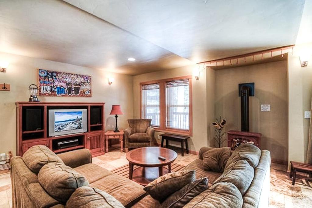 a living room with a couch and a tv at Sugar House in Soda Springs