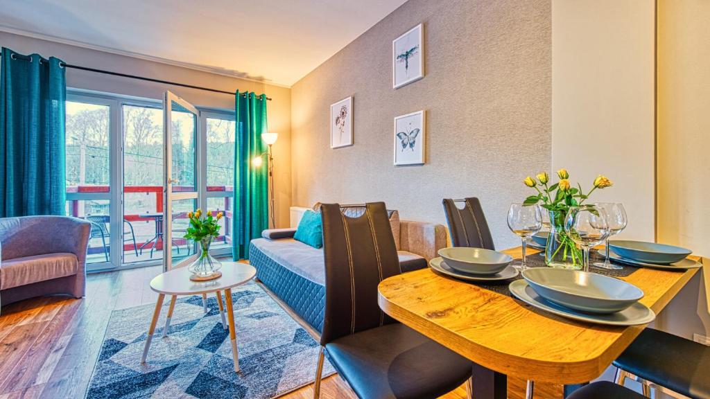 希维拉杜夫-兹德鲁伊Apartament Spokojny Holiday Mountain Residence - 5D Apartamenty的带桌子和沙发的餐厅