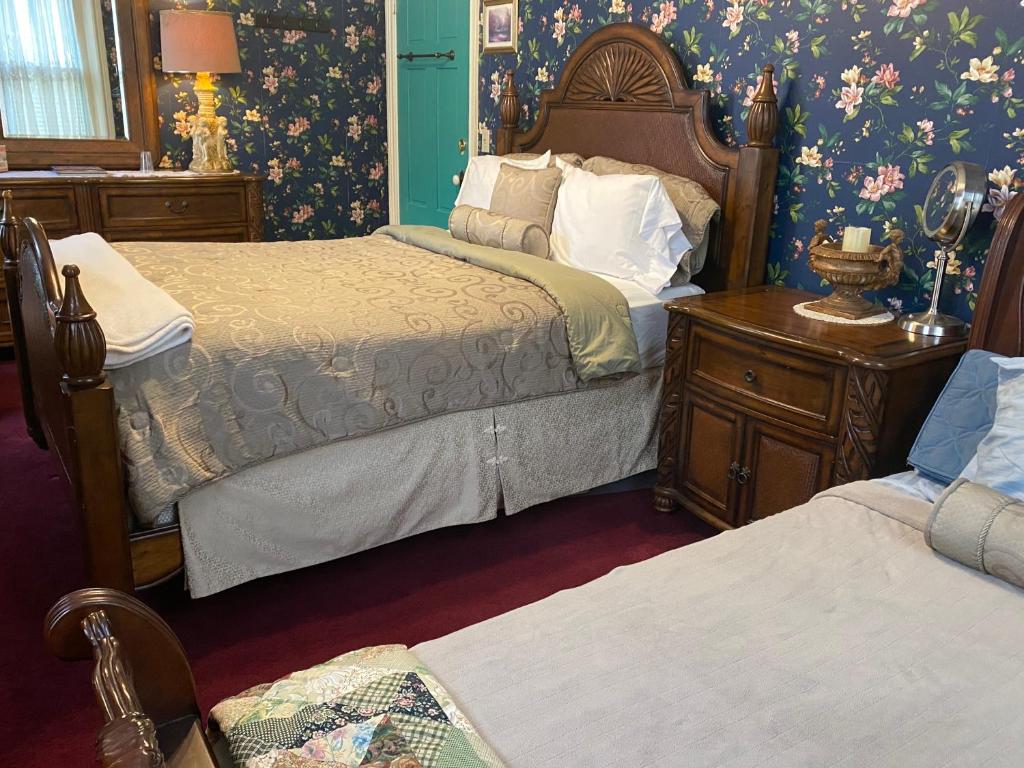 a bedroom with two beds and floral wallpaper at Susquehanna Manor Inn in Marietta