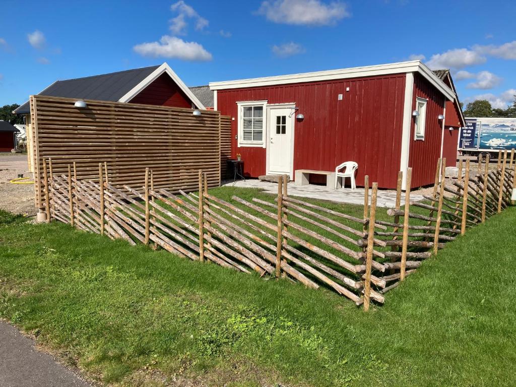 a red house with a fence in front of it at Smeakalles annex in Tvååker