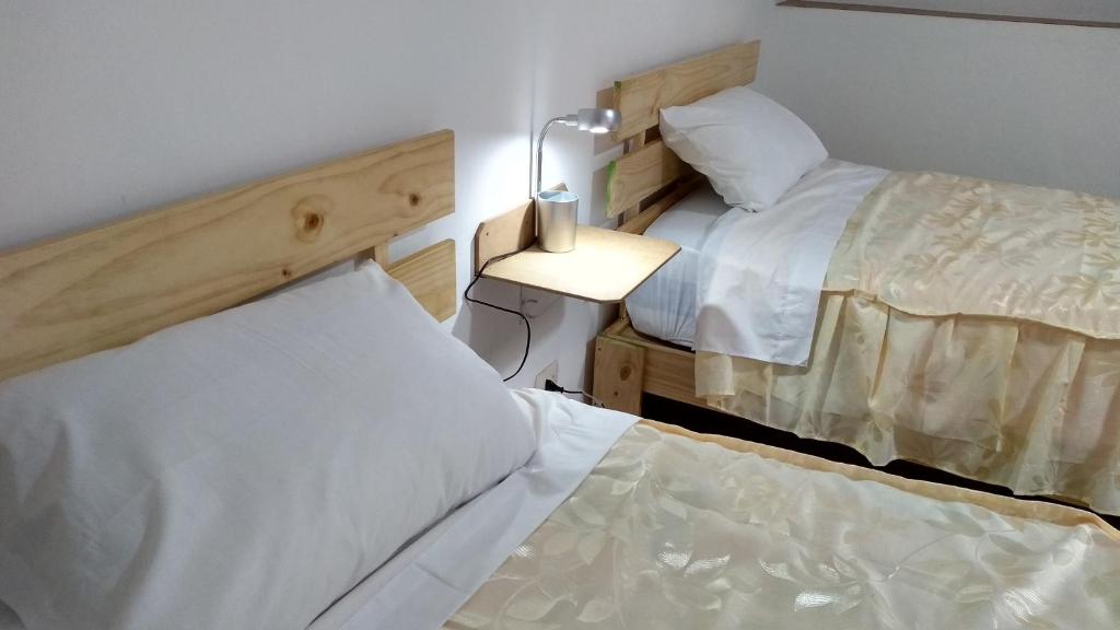 Zimmer mit 2 Betten und einer Lampe auf einem Tisch in der Unterkunft Casa Anais& Nicolas Cusco Htl Económico in Cusco