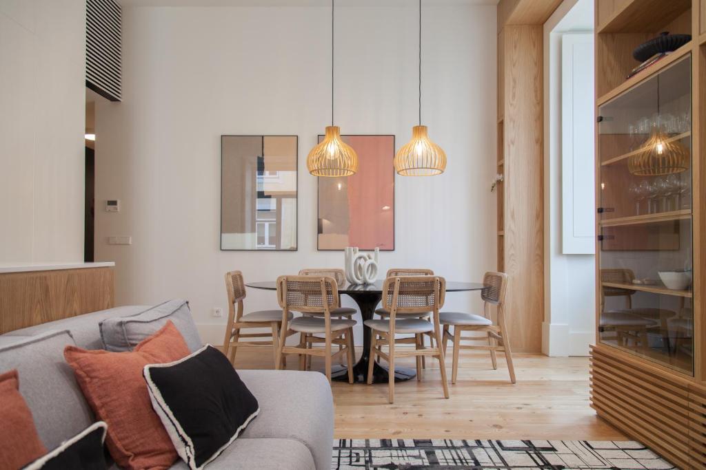 a living room with a couch and a table and chairs at FLH Praça Comércio Tropical Flat in Lisbon