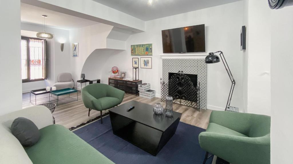 salon z zielonymi krzesłami i kominkiem w obiekcie Casa La Aldaba w mieście Montejaque