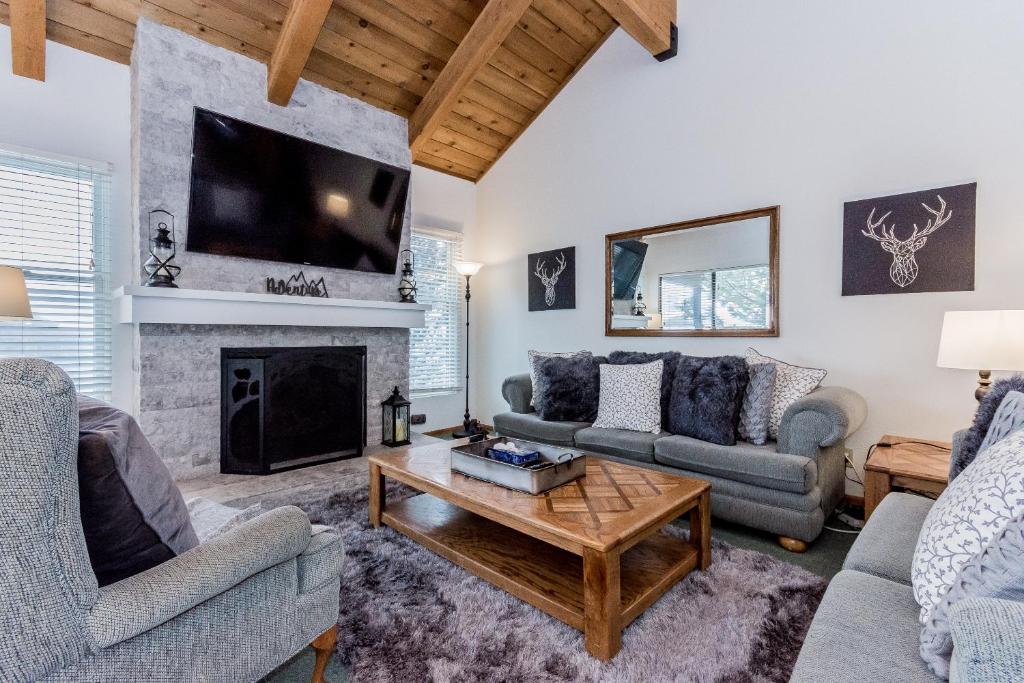 sala de estar con 2 sofás y chimenea en Val d'lsere # 21, en Mammoth Lakes