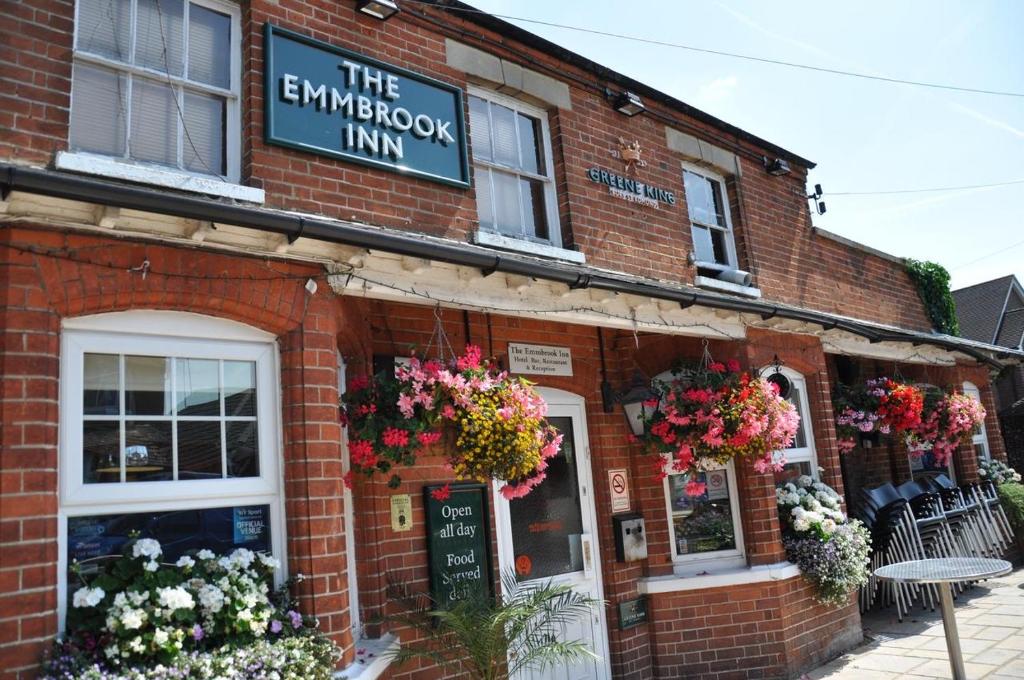 um edifício de tijolos com flores na frente em The Emmbrook Inn Hotel em Wokingham