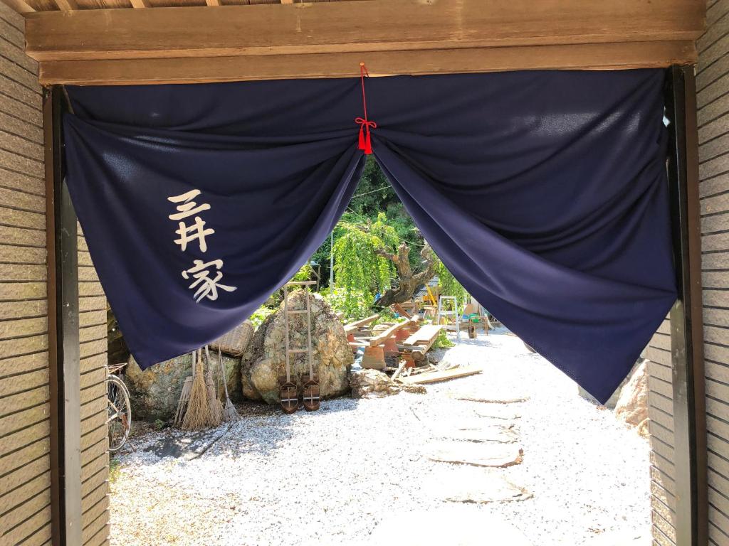 a blue curtain with chinese writing on the side of a building at 三井家ペットと泊れる一軒家らんまんで話題の牧野植物園まで25分 in Mimase