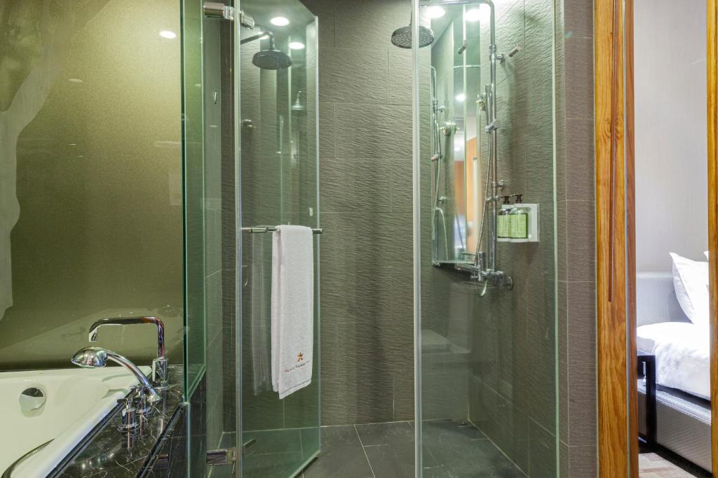 a glass shower in a bathroom with a sink at Pacific Business Hotel in Taipei