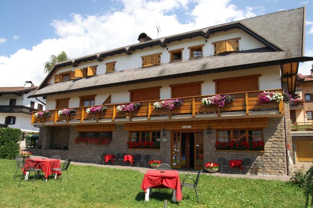 ein Gebäude mit Tischen und Stühlen davor in der Unterkunft Hotel 2 Camini in Baselga di Pinè