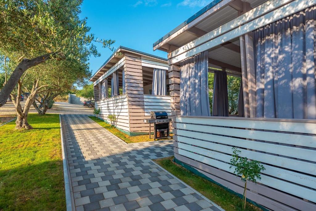 a wooden house with a pathway next to it at Mobile home Pecten exclusive 2 in Pakoštane