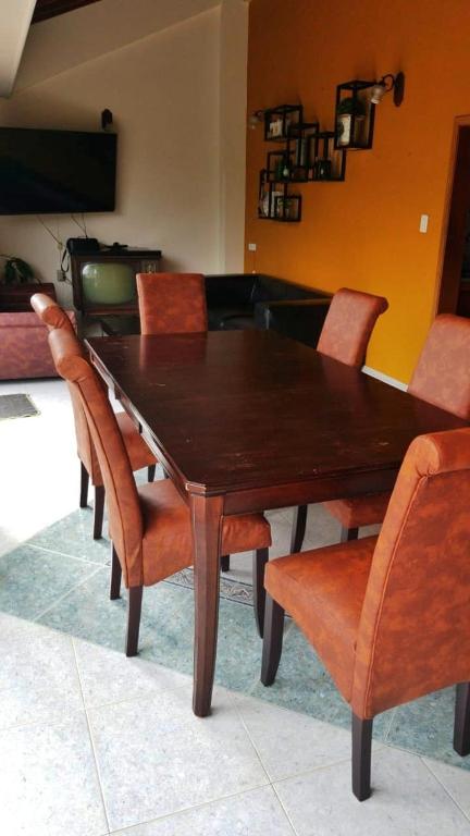 a dining room table with orange chairs and a wooden table at Sam'S VIP Hostel San Gil in San Gil