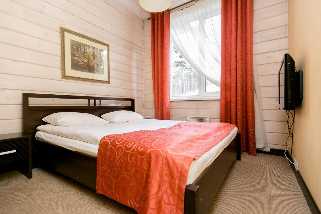 1 dormitorio con 1 cama, TV y ventana en Hotel Shale, en Novokuznetsk