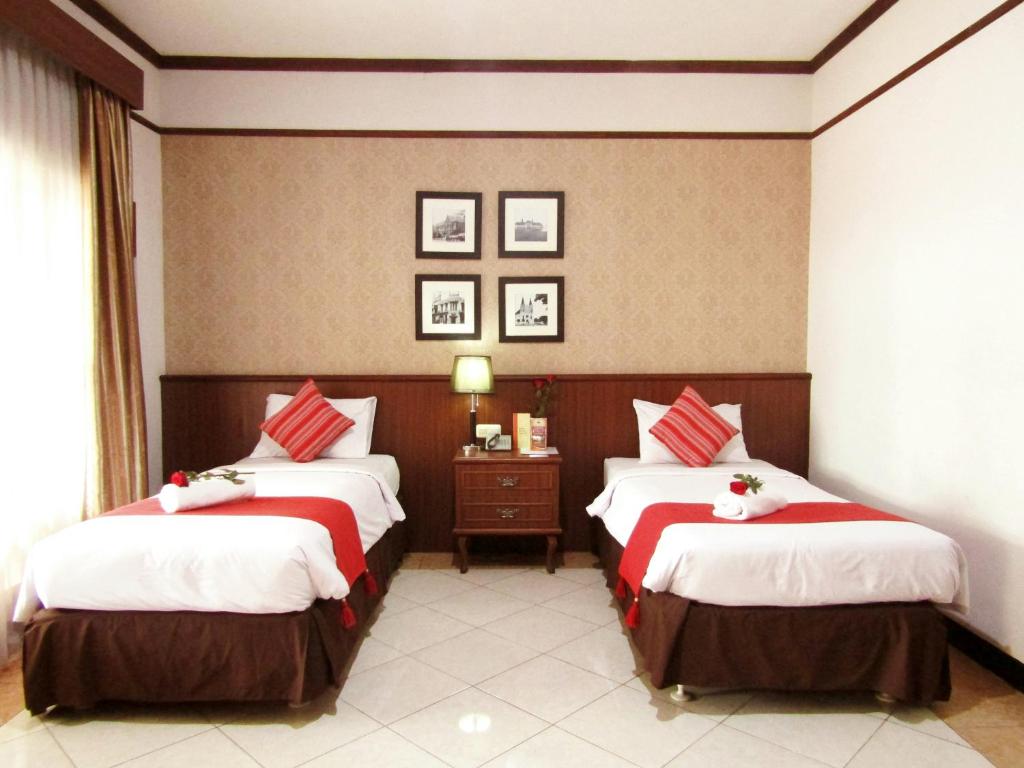 Postel nebo postele na pokoji v ubytování Hotel Pelangi Malang, Kayutangan Heritage
