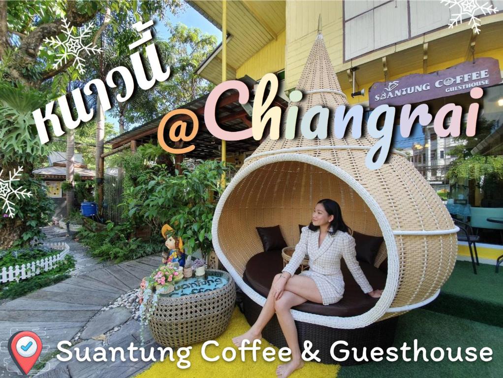 una mujer sentada en una cápsula de mimbre frente a un edificio en SuanTung Coffee & Guesthouse en Chiang Rai