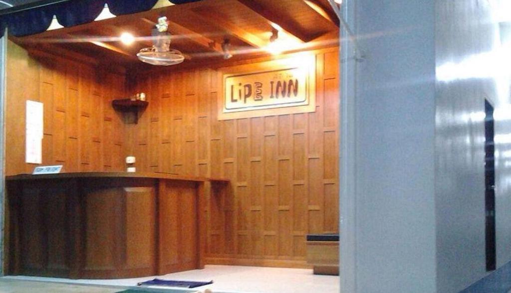 uma sala de tribunal com uma secretária e uma placa na parede em Lipe Inn em Koh Lipe
