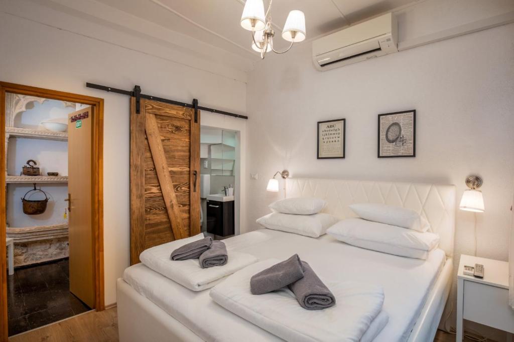 1 dormitorio con 1 cama blanca y 2 toallas en Private Accomodation Linda, en Dubrovnik