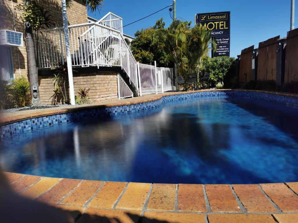 a large blue swimming pool in front of a building at Limassol Motel in Gold Coast
