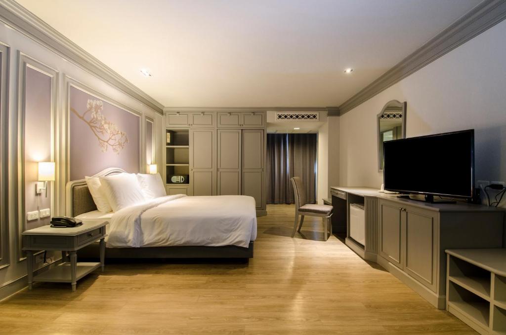 um quarto com uma cama e uma televisão de ecrã plano em The Pantip Hotel Ladprao Bangkok em Banguecoque