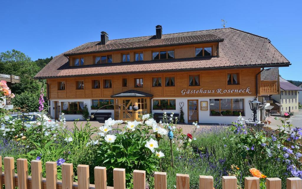 una gran casa de madera con un jardín delante de ella en Gästehaus Roseneck, en Todtmoos