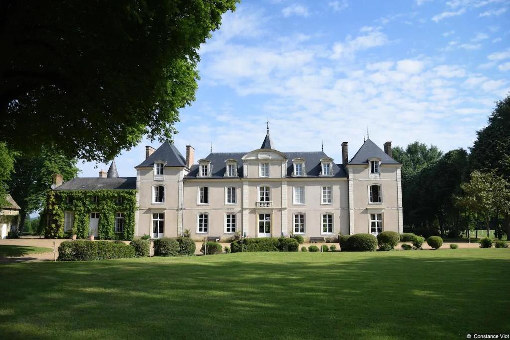 a large white house with a large lawn at Hotel Haras De La Potardiere in Crosmières